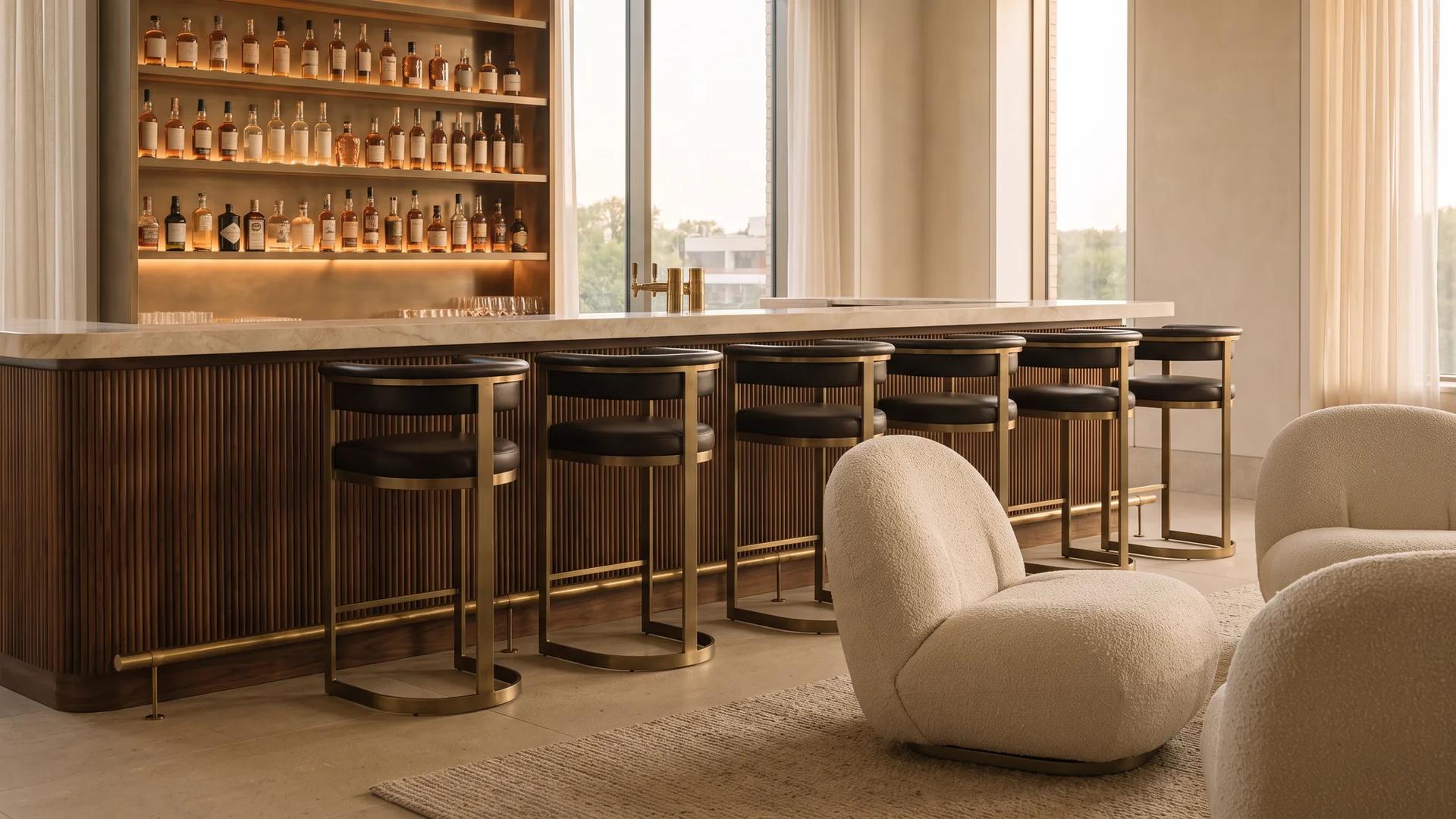 Hotel lobby bar with a fluted walnut counter, marble top and leather bar stools