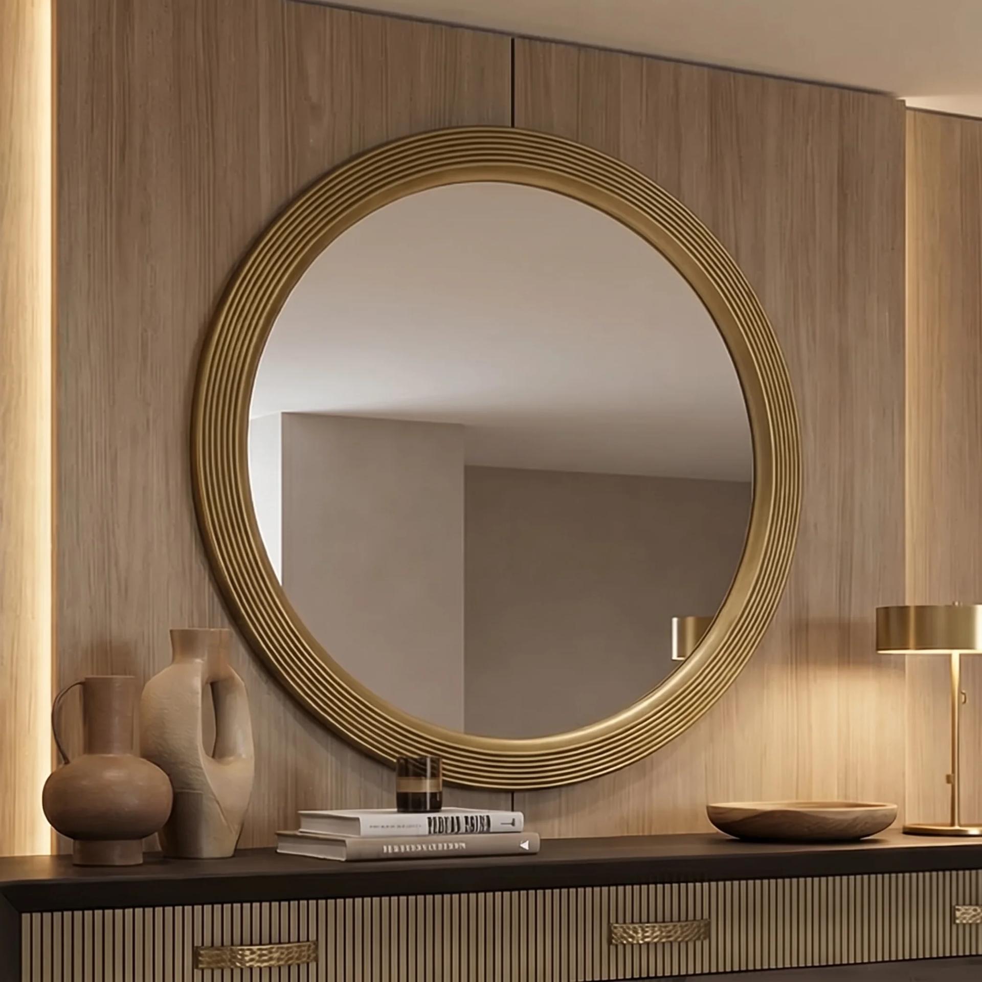 Casablanca round mirror with ribbed brass frame on a wood-panelled wall above a console