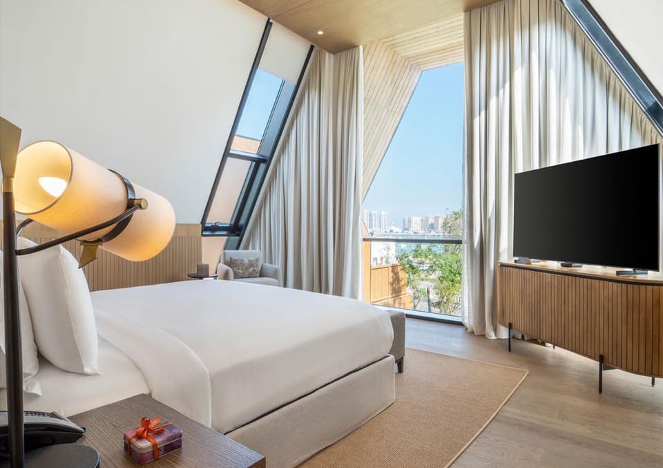 Villa bedroom furniture produced by Archidecors for Katara Hills in Qatar: bed with upholstered headboard and a low timber TV unit
